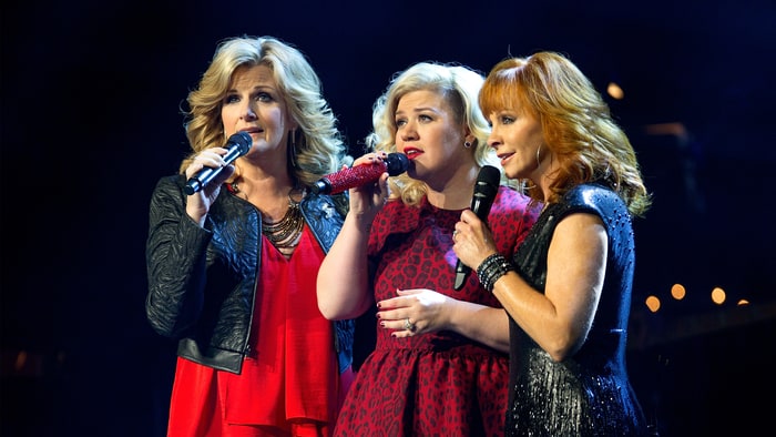 In a Jaw-dropping Holiday Moment, Kelly Clarkson, Radiating In A Stunning Red Gown, Teams Up With Country Music Icons Trisha Yearwood And Reba McEntire For A Breathtaking, Soul-Stirring Rendition Of “Silent Night.” Their Voices, Blending In Flawless Harmony, Create A Powerful A Cappella Performance Infused With A Gospel-Inspired Touch That Sends Chills Down The Spine. The Raw Emotion And Pure Beauty Of The Trio’s Performance Have Captivated Over 45 Million Viewers On YouTube, Leaving Fans In Awe